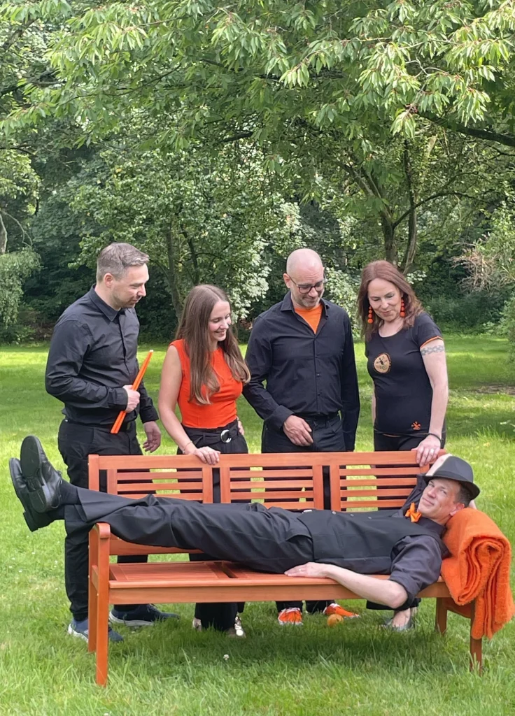 Die Band Friday Orange Club im Garten mit einer Bank