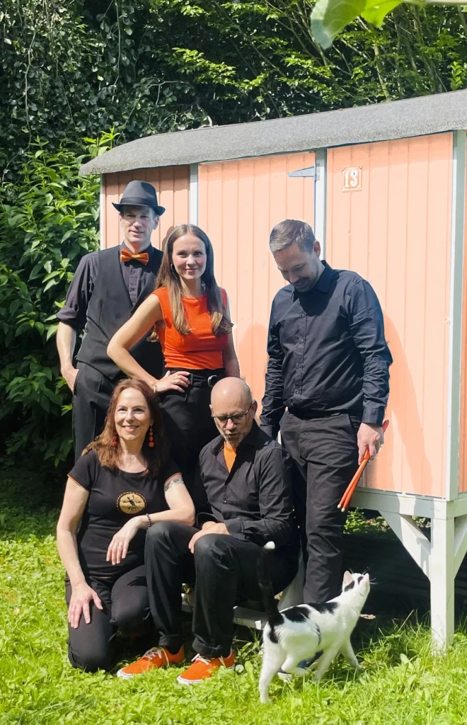 Die Band Friday Orange Club vor einem Bauwagen mit Bandkatze Cookie